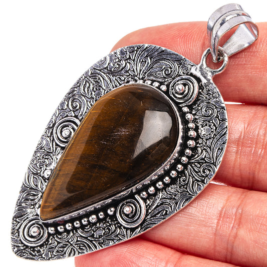 Tiger's eye pendant with German silver teardrop setting and ornate swirl border