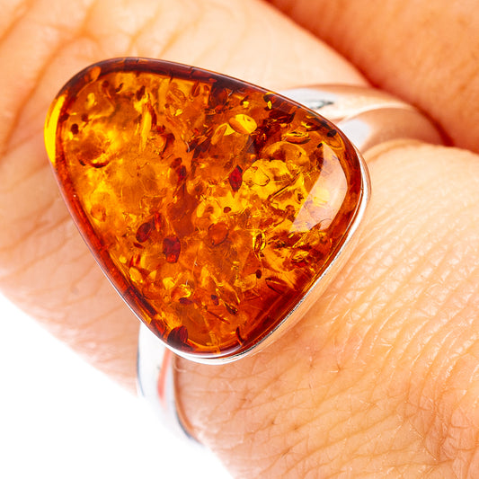 Amber teardrop ring with silver prongs, warm honey-orange stone setting
