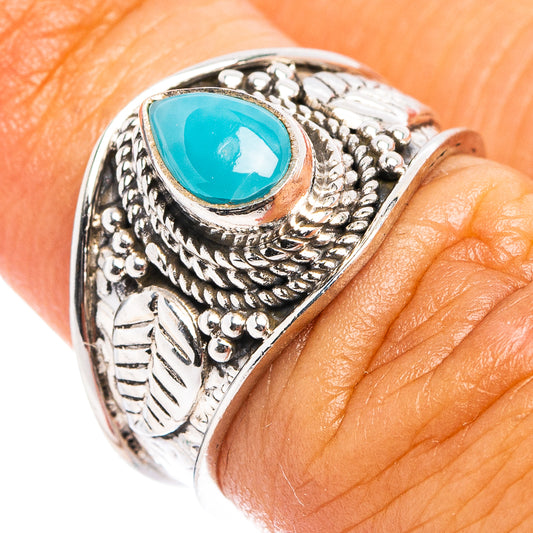 Sterling silver cocktail ring with oval blue gemstone and ornate engraved band