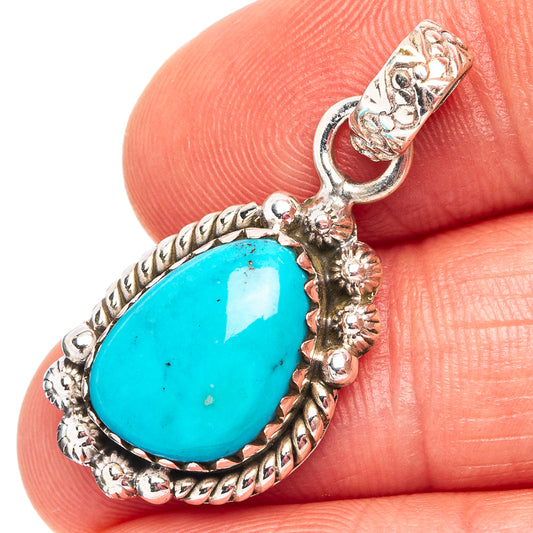 Oval turquoise cabochon pendant with ornate .925 sterling silver frame and bail