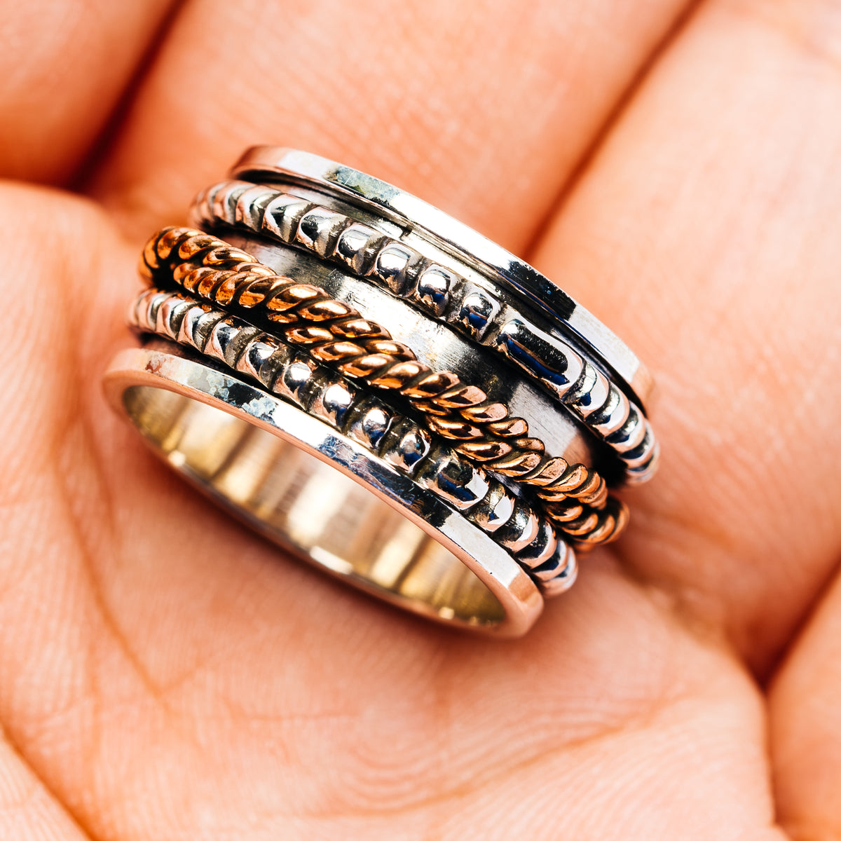 Sterling silver spinner ring, copper-toned center inlays and patterned outer band, size 5.75