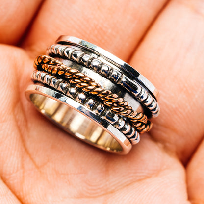 Sterling silver spinner ring, copper-toned center inlays and patterned outer band, size 5.75
