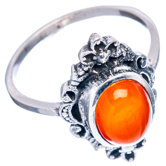 Sterling silver ring with oval red-orange gemstone bezel and detailed floral settings