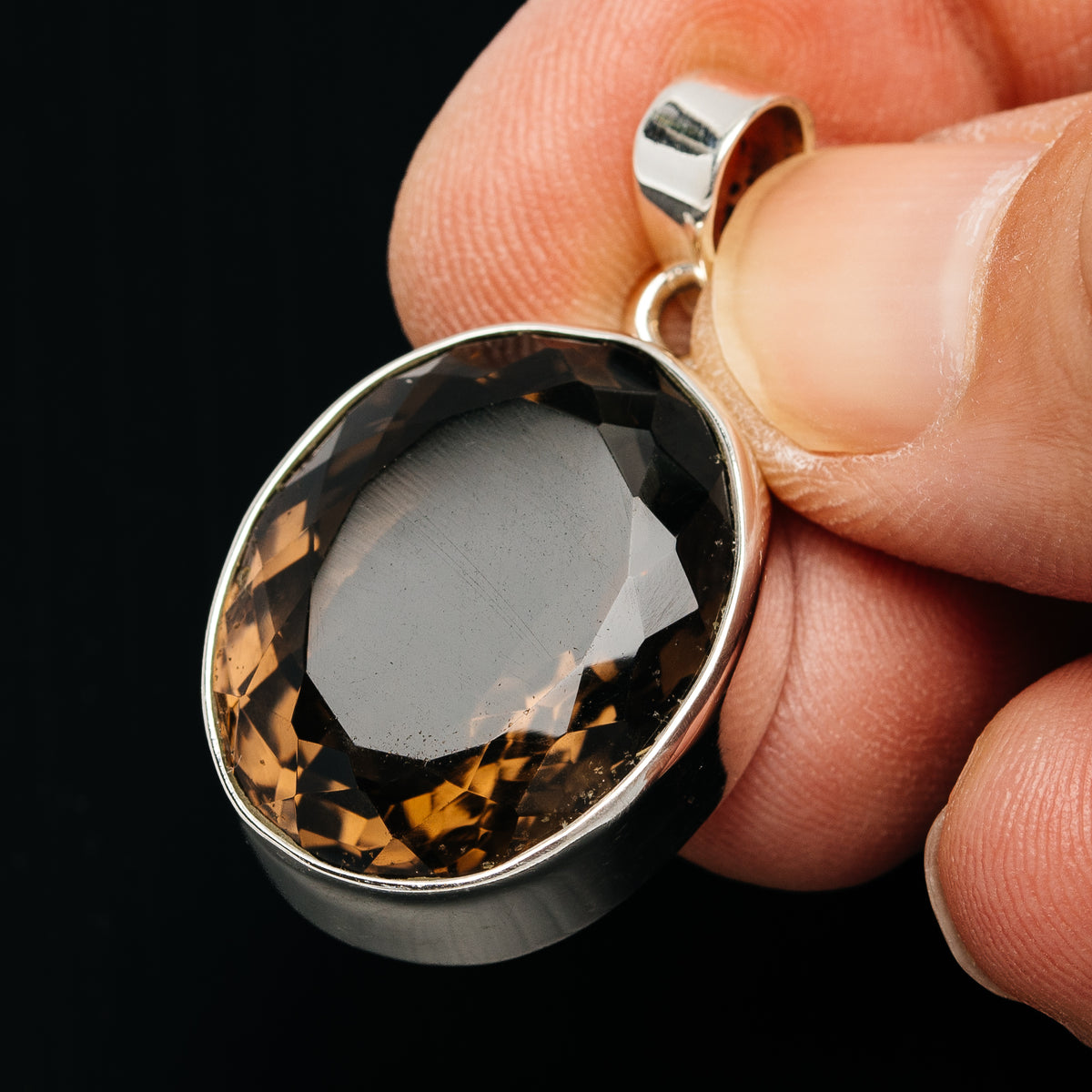 Faceted smoky quartz oval pendant in sterling silver bezel with loop