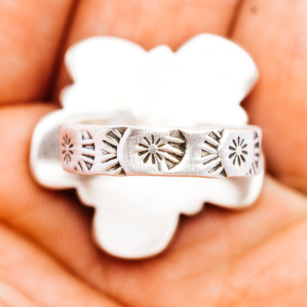 Silver ring band with engraved sunburst pattern and scalloped edge