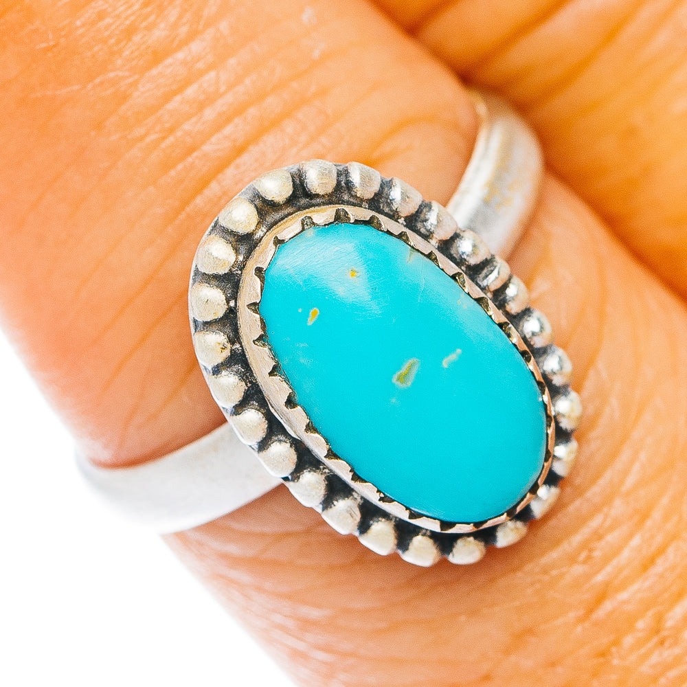 Sterling silver turquoise oval ring with beaded bezel on finger