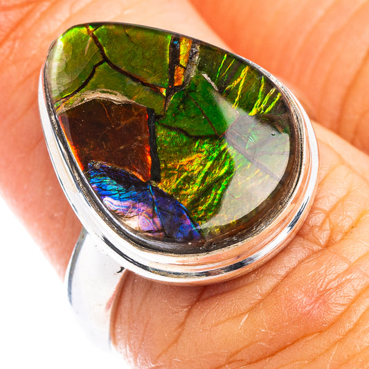 Sterling silver ammolite ring with oval iridescent gemstone in green and blue, top view.