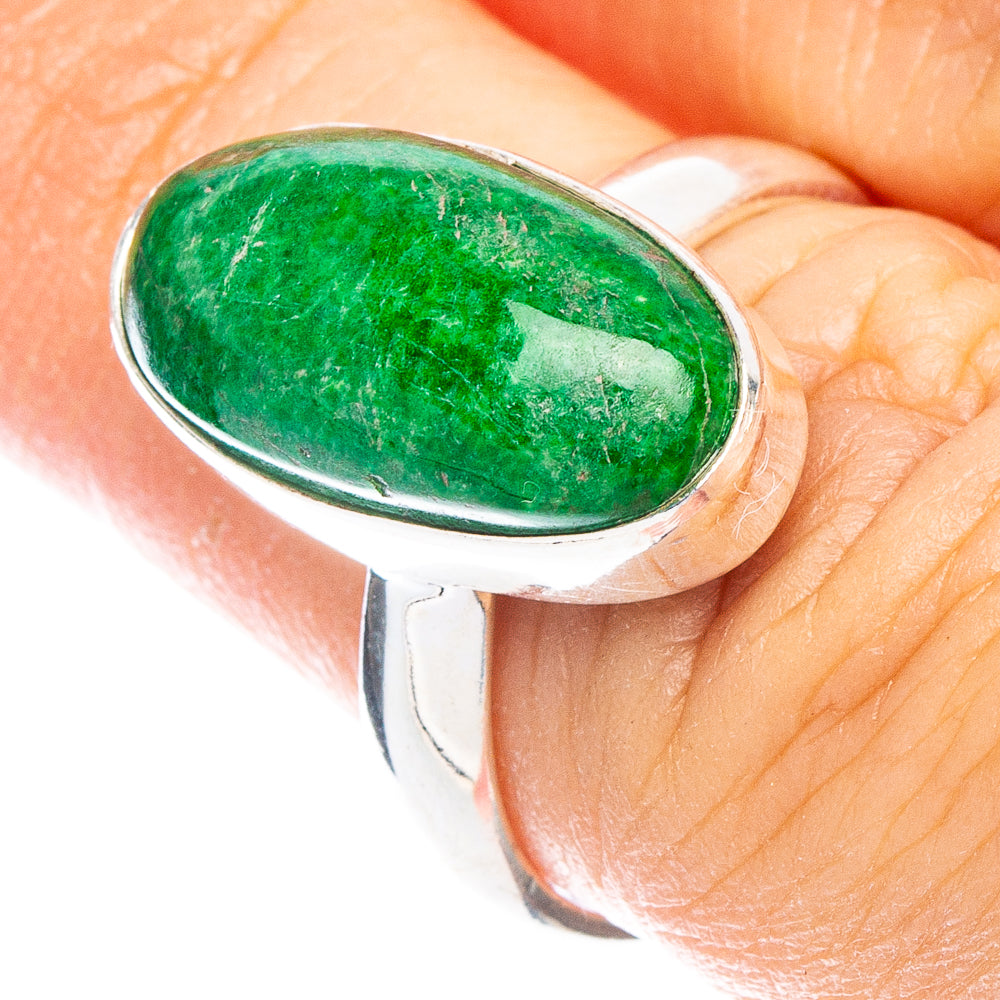 Oval green maw sit sit gemstone ring with silver bezel on a finger