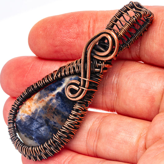 Oxidized copper wire wrap pendant with blue sodalite teardrop stone and coil frame