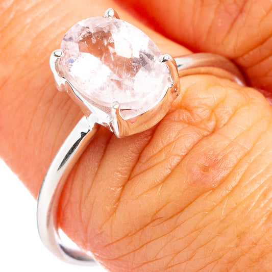 Oval pink morganite ring on hand, silver band with prong-set gemstone