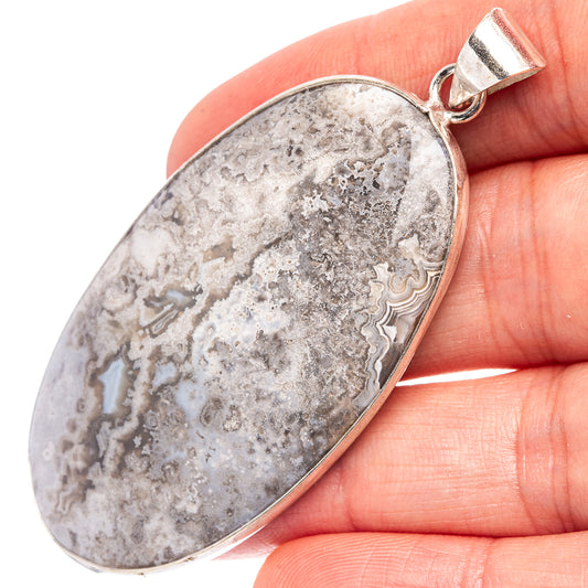 Silver-plated oval lace agate pendant with gray stone and loop bail.