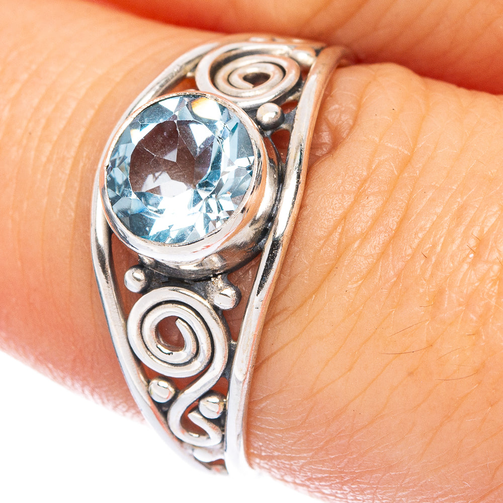 Sterling silver ring with round blue topaz gemstone in ornate curved bezel