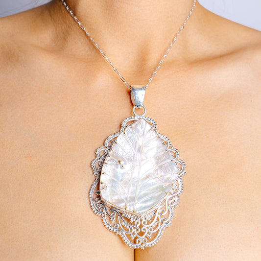 Sterling silver mother-of-pearl pendant with ornate filigree and oval iridescent stone