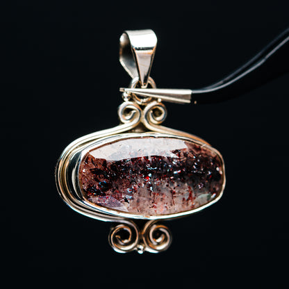 Sterling silver oval lepidocrocite pendant with glittery red-brown stone and scroll bail