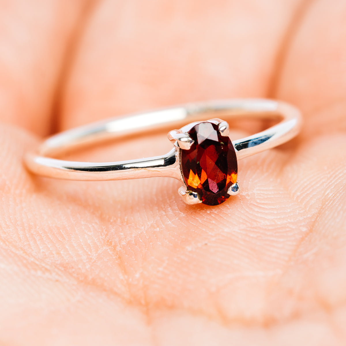 Sterling silver stackable ring with oval dark red garnet center, slim band