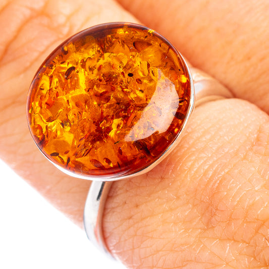 Oval amber cabochon ring in .925 sterling silver, close-up on hand