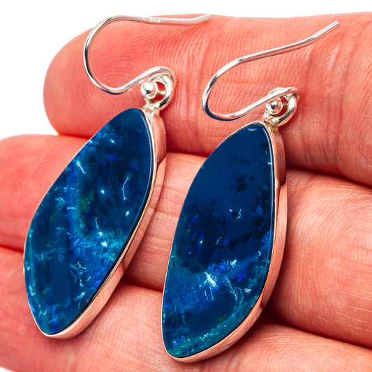 Blue teardrop opal drop earrings on hands, sterling silver hook with bezel setting