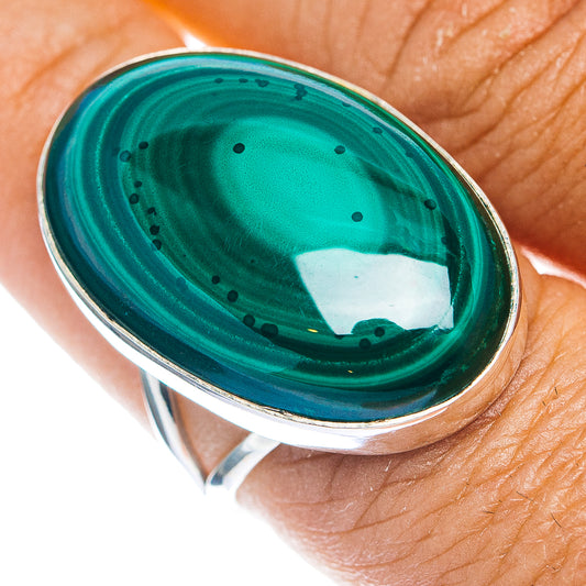 Oval malachite gemstone set in sterling silver bezel ring, detailed green and black bands.
