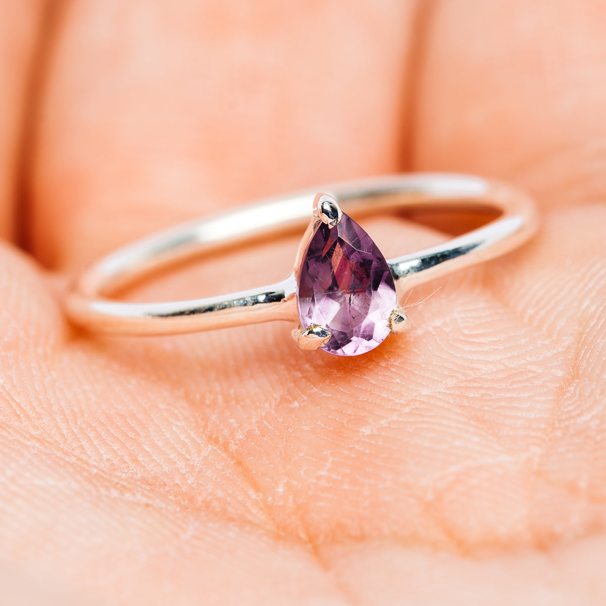 Sterling silver amethyst ring with faceted purple teardrop stone, side view