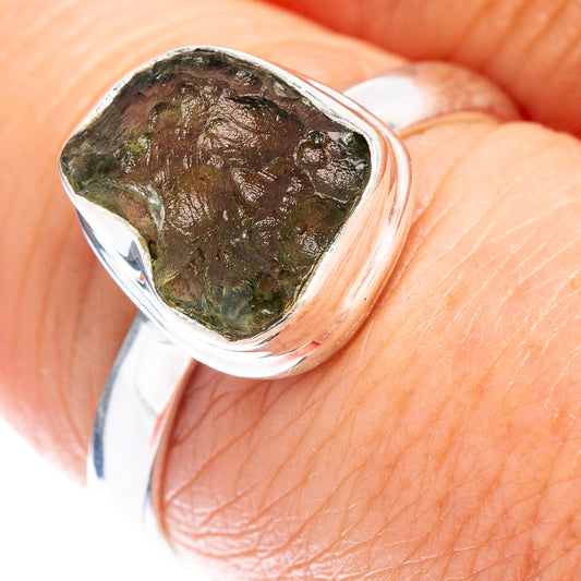 Sterling silver ring close-up with textured green bezel-set stone on finger