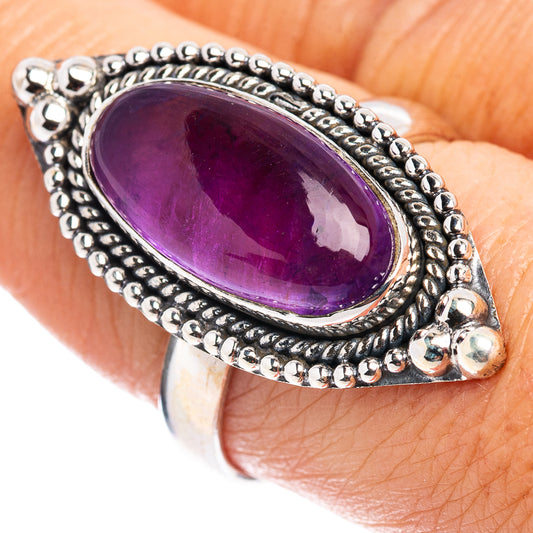 Amethyst oval sterling silver ring with ornate bead bezel, worn on finger
