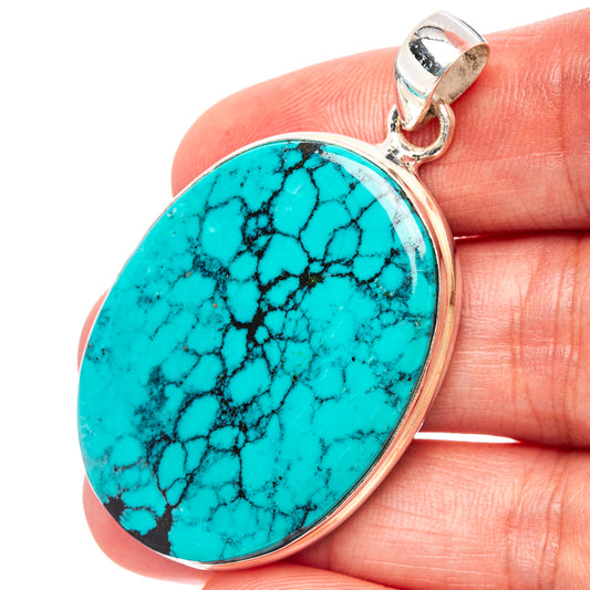 Oval turquoise pendant with black webbed matrix, set in .925 sterling silver bezel.