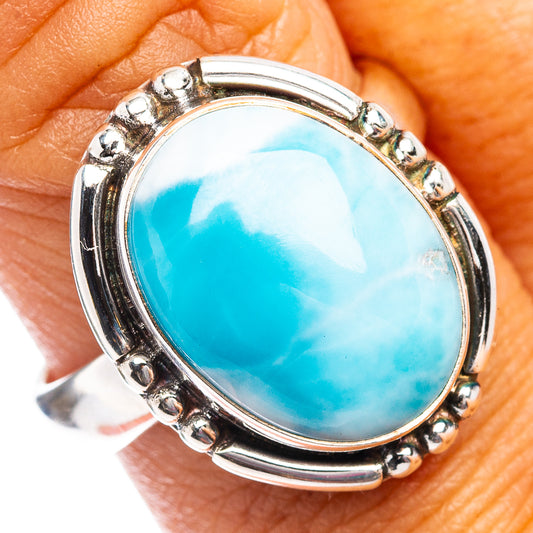 Sterling silver larimar ring on finger, oval turquoise-blue cabochon bezel
