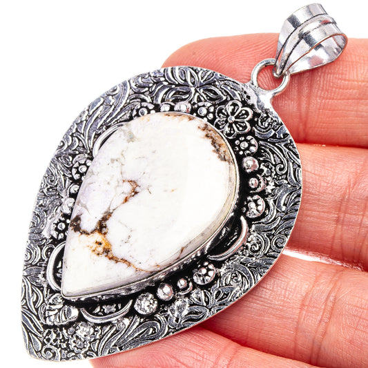 Silver-tone teardrop pendant with white and brown stone in ornate filigree bezel