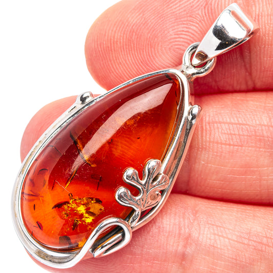 Baltic amber pendant with red-orange teardrop stone and silver leaf charm bail