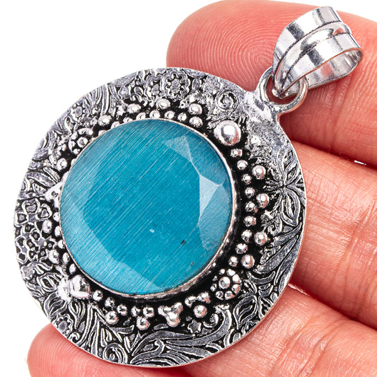 Blue onyx pendant in German silver with round blue cabochon and ornate border