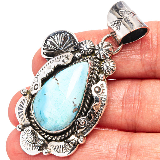 Turquoise teardrop pendant in .925 sterling silver with ornate Native-style border and bail