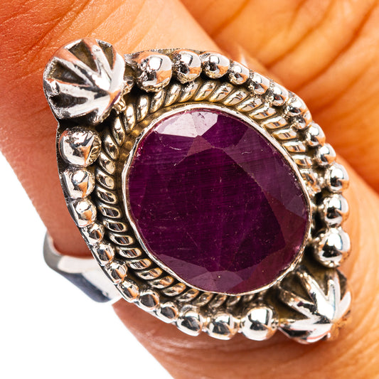 Oval dark red ruby-style ring with ornate silver setting and prong details