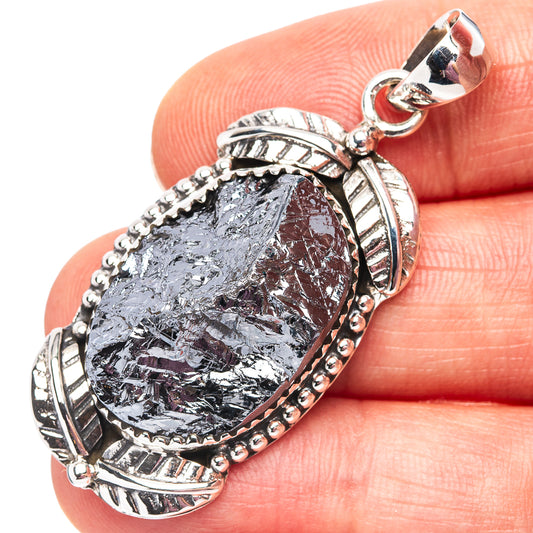 925 sterling silver pendant bail above faceted gray-blue teardrop stone on finger