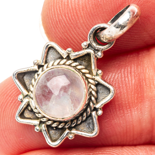 Sterling silver moonstone pendant with ornate star-shaped bezel and round cabochon