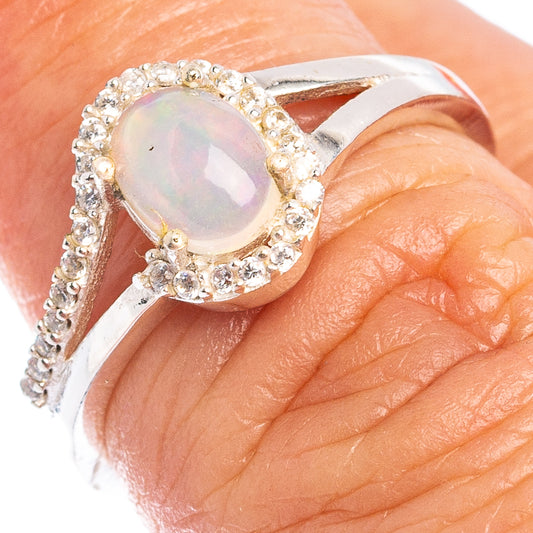 Sterling silver ring with round opal and cubic zirconia halo, on finger