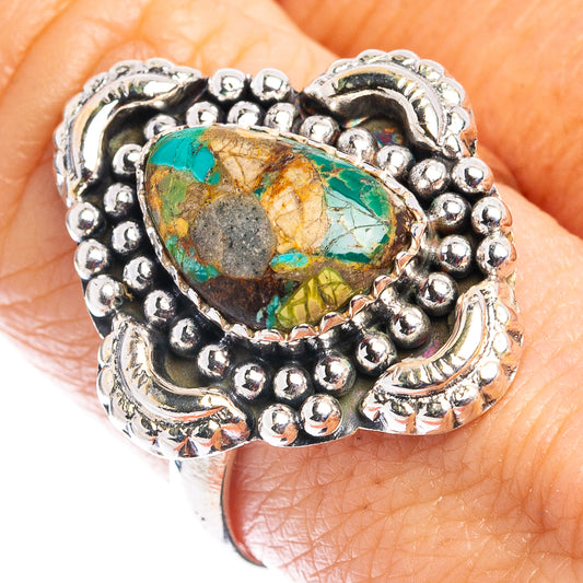 Sterling silver turquoise ring on finger, oval stone in detailed beadwork bezel