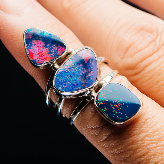 Sterling silver doublet opal ring with three oval stones, blue and red fire highlights.