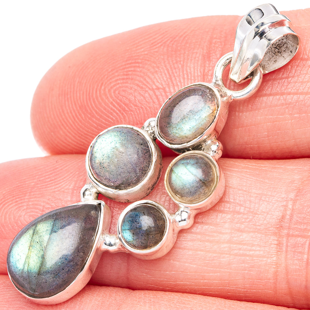 Labradorite pendant close-up: five iridescent oval stones in silver with bail