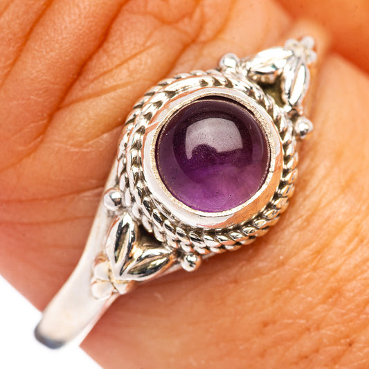 Close-up sterling silver amethyst ring on hand, round purple stone bezel detail