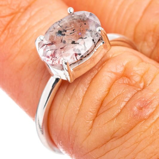 Sterling silver ring close-up with prong-set oval speckled stone on hand