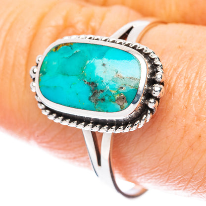 Oval turquoise cabochon ring with ornate sterling silver bezel and split shank