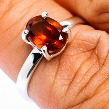 Sterling silver garnet ring with a large oval reddish-orange gemstone and four prongs