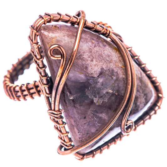 Close-up amethyst wire-wrapped ring, teardrop purple stone with copper frame and loops
