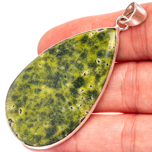 Teardrop stichtite pendant in green with silver-plated loop, shown close-up