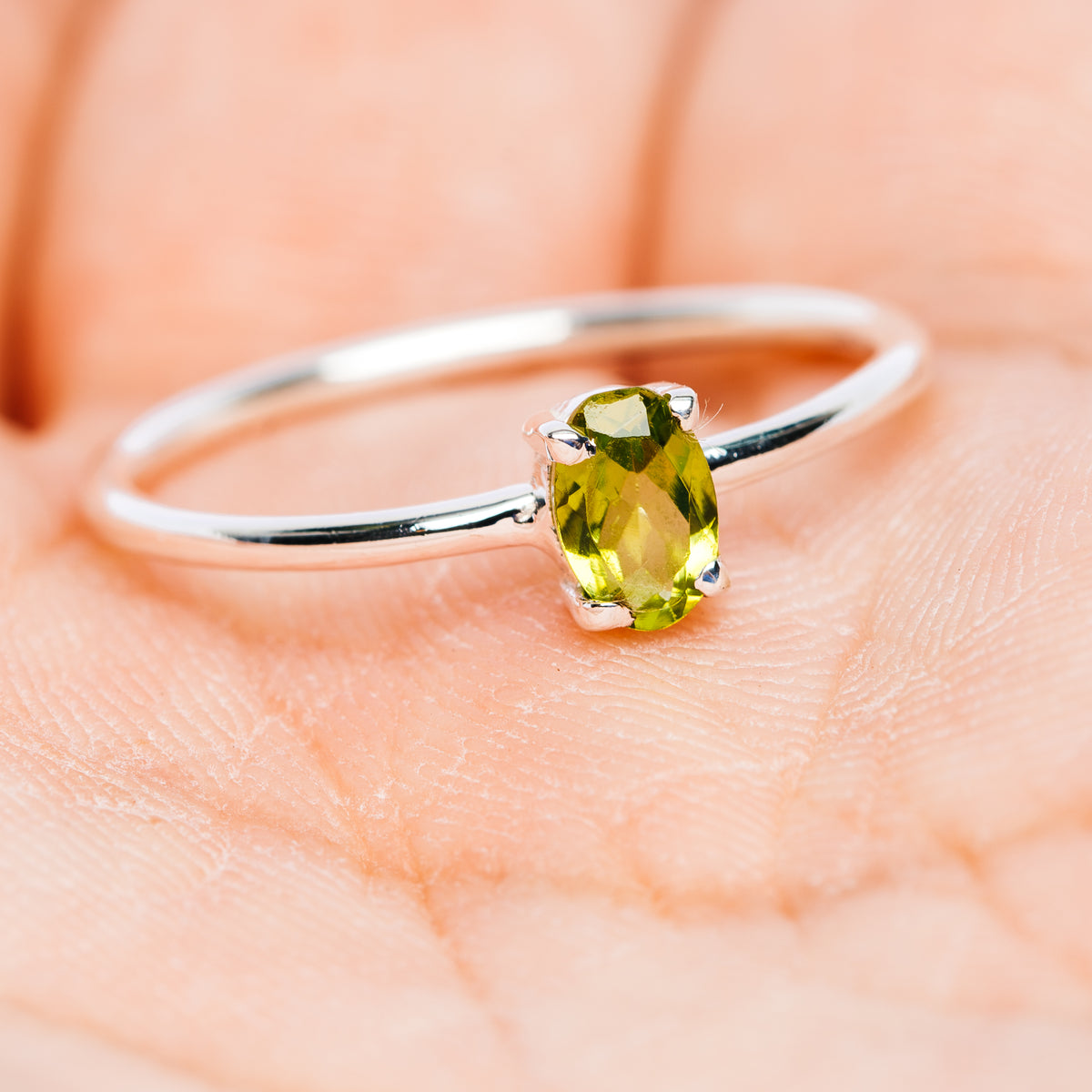 Sterling silver ring with green oval peridot on slender band