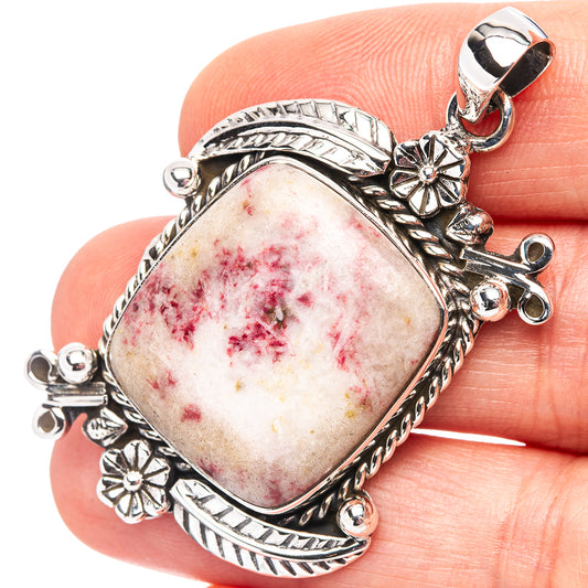 Oval cinnabar pendant in .925 sterling silver with ornate bezel and red speckled cabochon