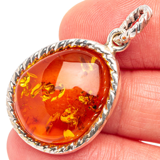 Close-up of sterling silver Baltic amber oval pendant with warm orange honey glass
