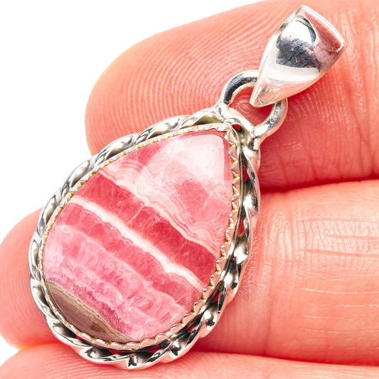Pink rhodochrosite teardrop pendant close-up with braided silver frame and loop bail