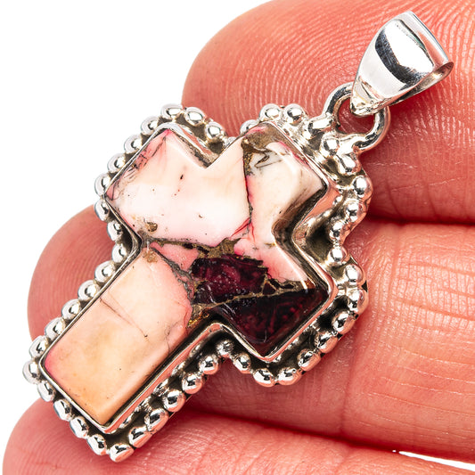 Cross pendant in .925 sterling silver with red, pink and cream stone inlay, close-up.