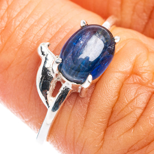 Sterling silver bird motif ring with oval blue gemstone on finger